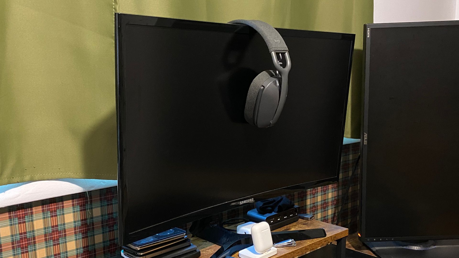 Logitech Zone Vibe 100 hanging on a curved monitor.
