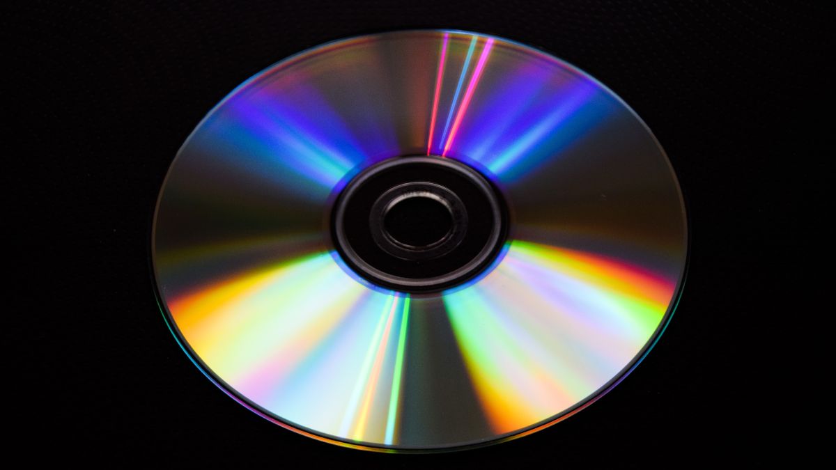 A DVD compact disc isolated on a black background.