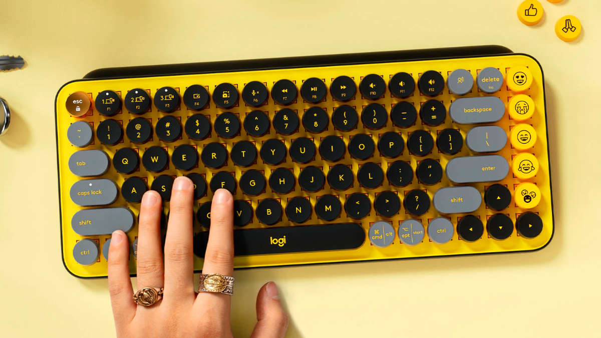 Logitech POP Keys Wireless Mechanical Keyboard sitting on a desk with a hand typing on it