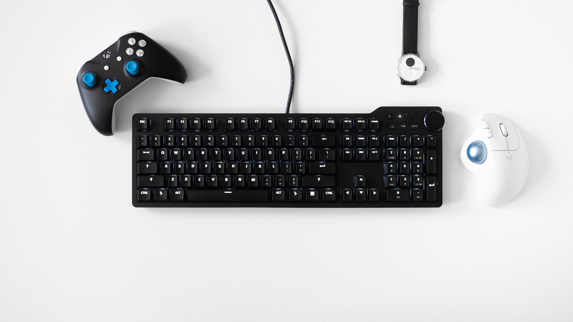 Das Keyboard 6 Professional with an xbox controller, watch, and trackball mouse surrounding it