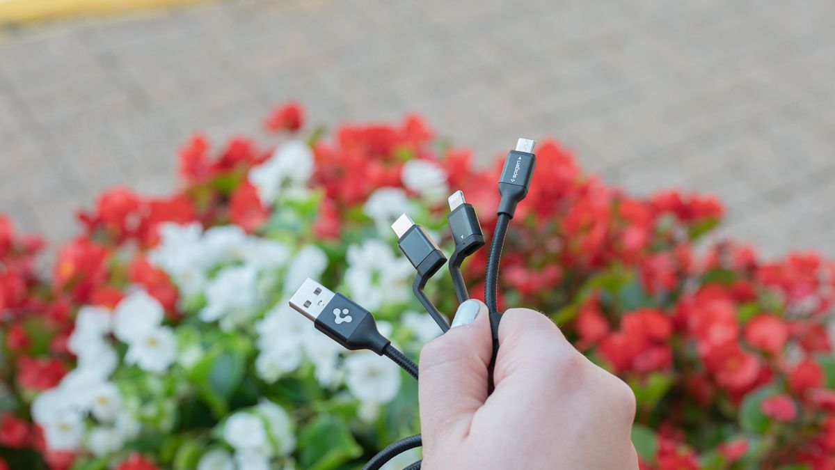Person holding the Spigen DuraSync 3-in-1 Universal Charger Cable