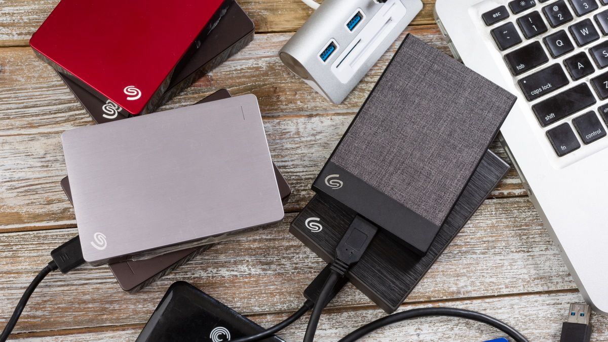 Portable hard drives next to a MacBook.
