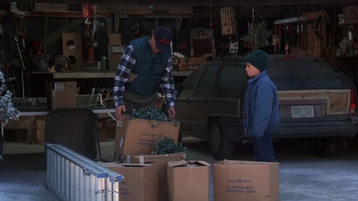 A man looks at boxes of tangled Christmas lights with this son.