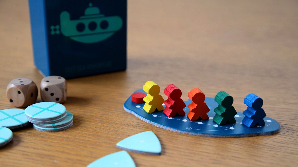 A cardboard submarine holding small wooden player models from the game Deep Sea Adventure.