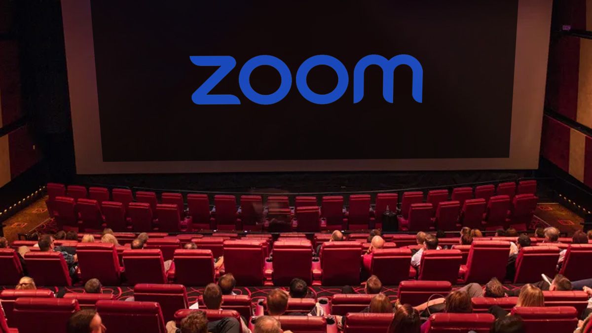 A photo of a movie theater with a large Zoom logo on the screen