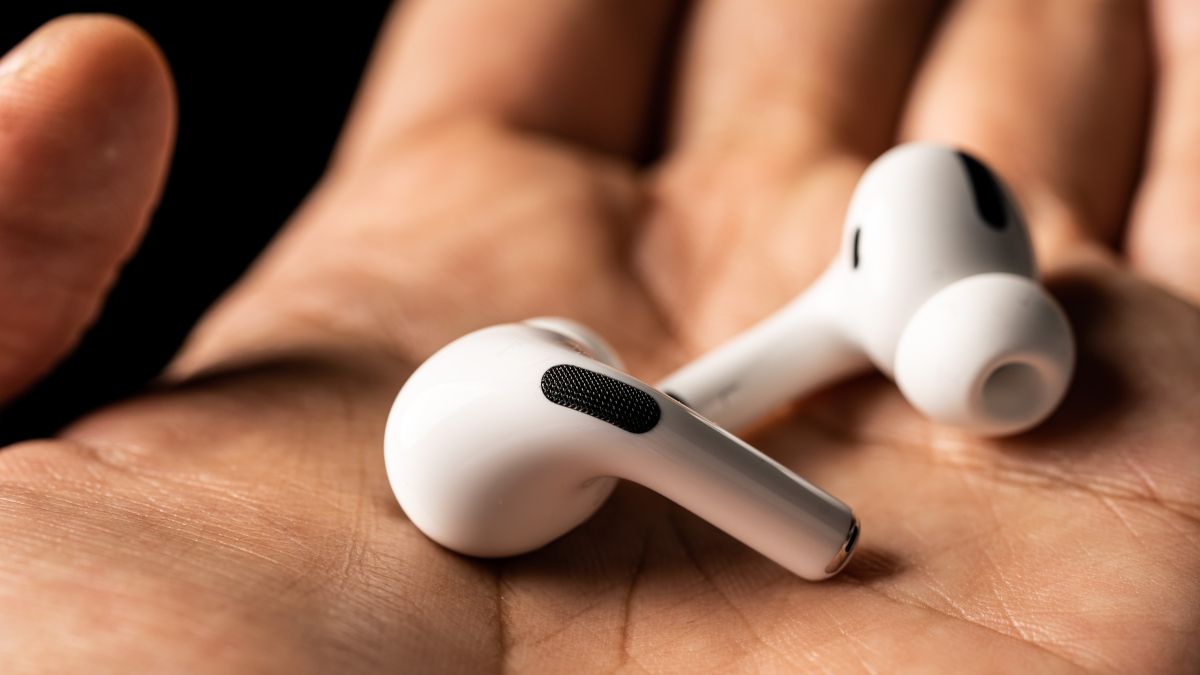 A pair of AirPods in a person's hands