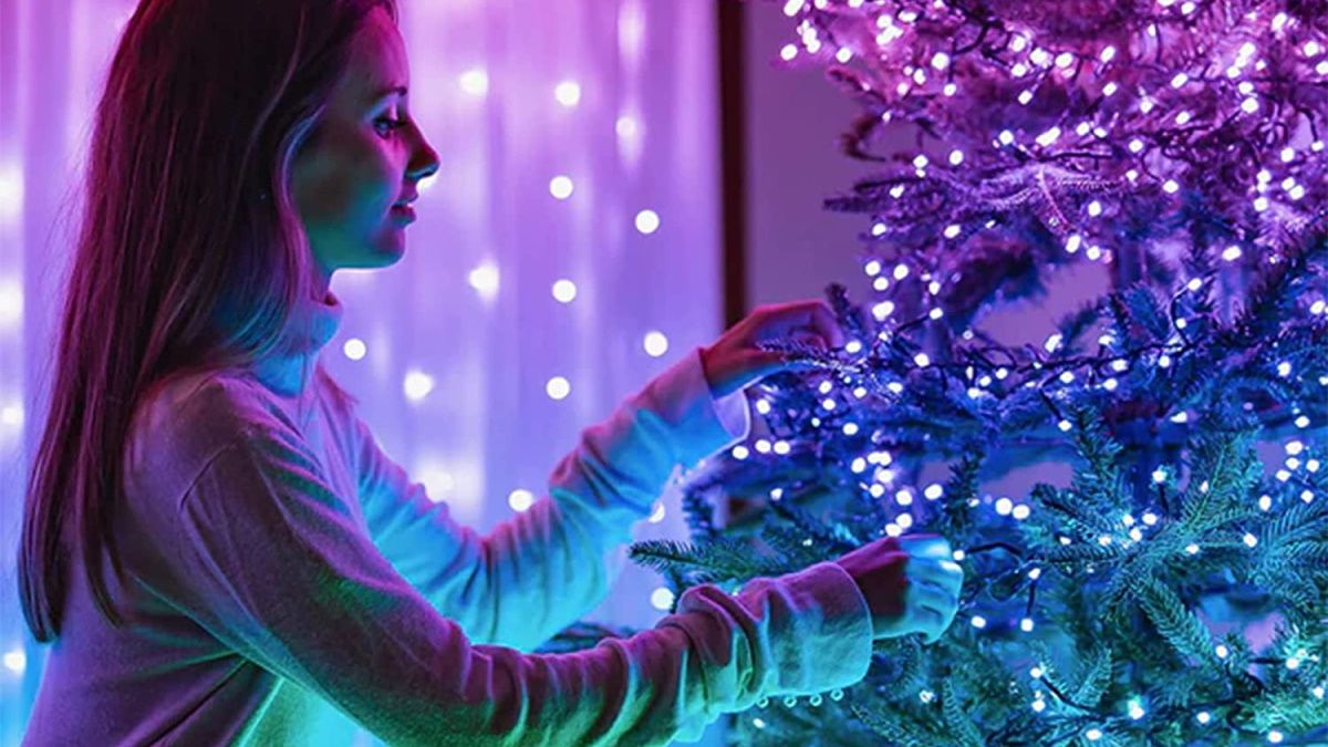 Person stringing Twinkly lights on Xmas tree