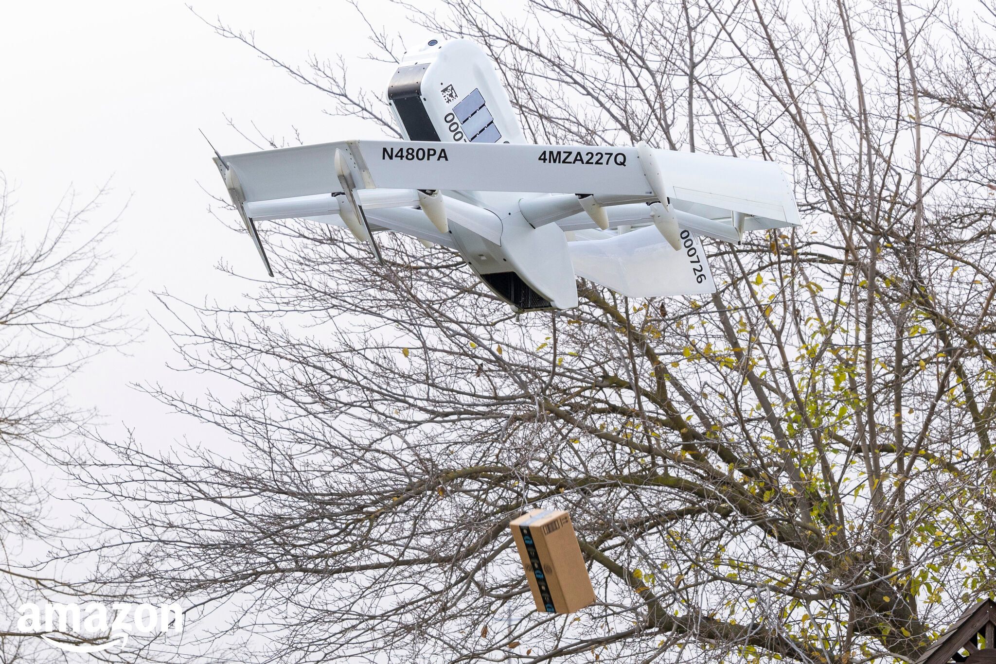 Amazon drone flying in air with a package hanging from a string