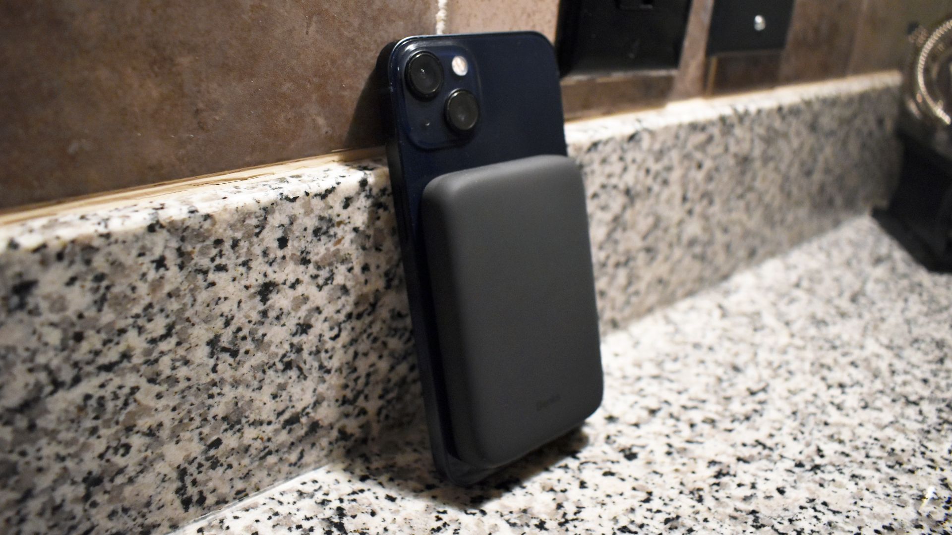 MagClap On-Go Power Bank on back of iPhone 13 resting on countertop