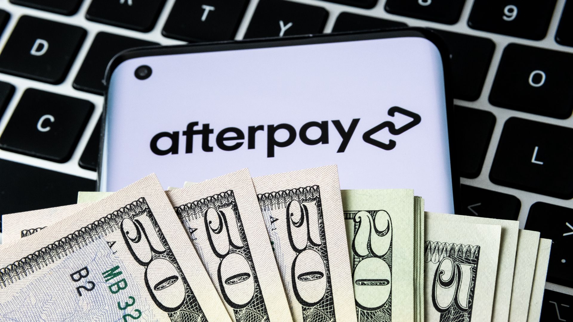 Afterpay app on a phone covered in money.