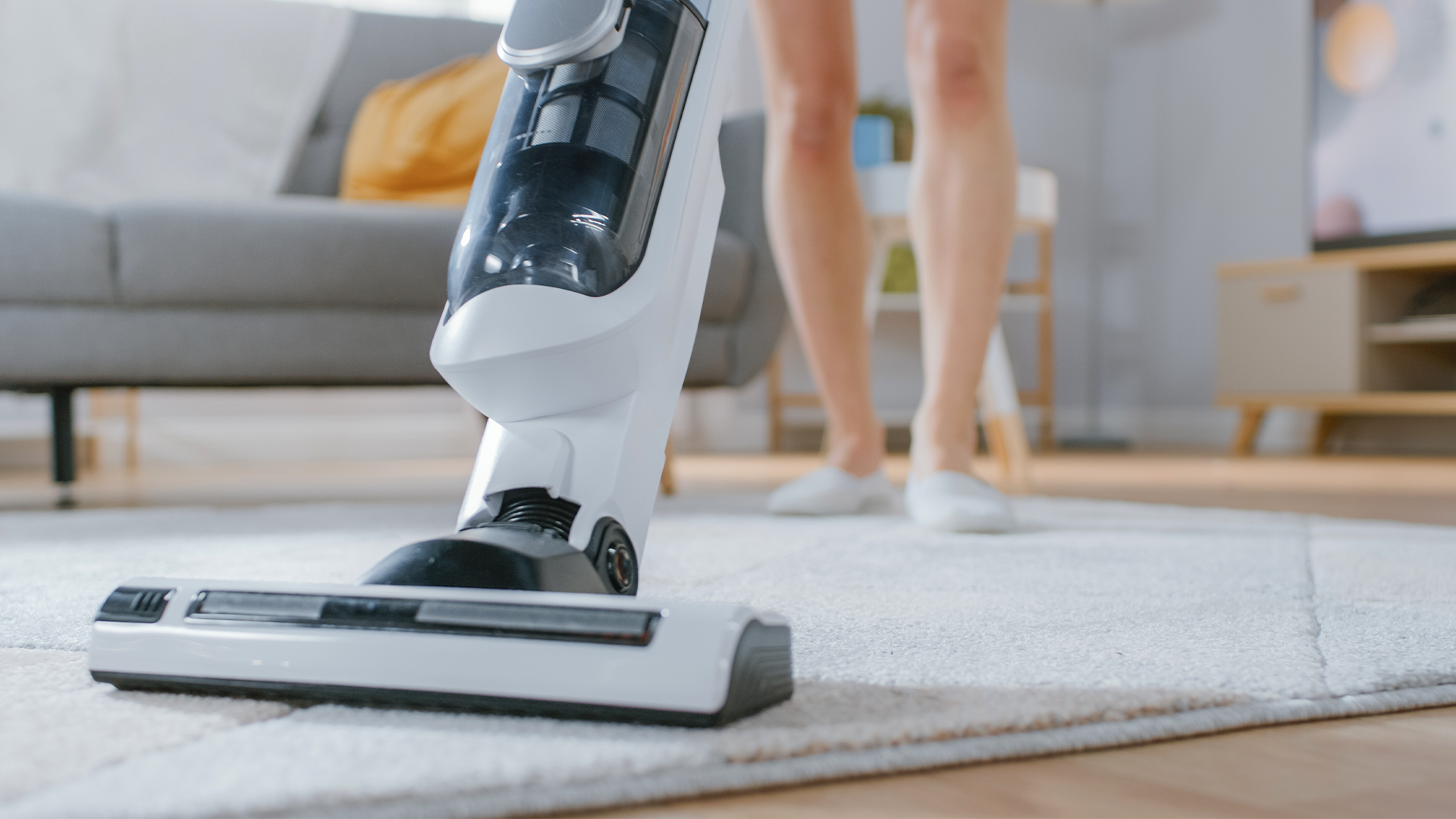 Using a cordless vacuum on a small rug.