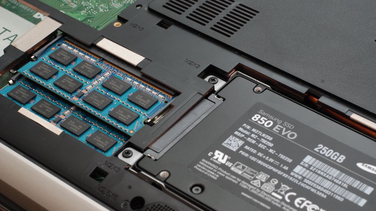 Open underside of a laptop with an SSD and RAM modules visible.