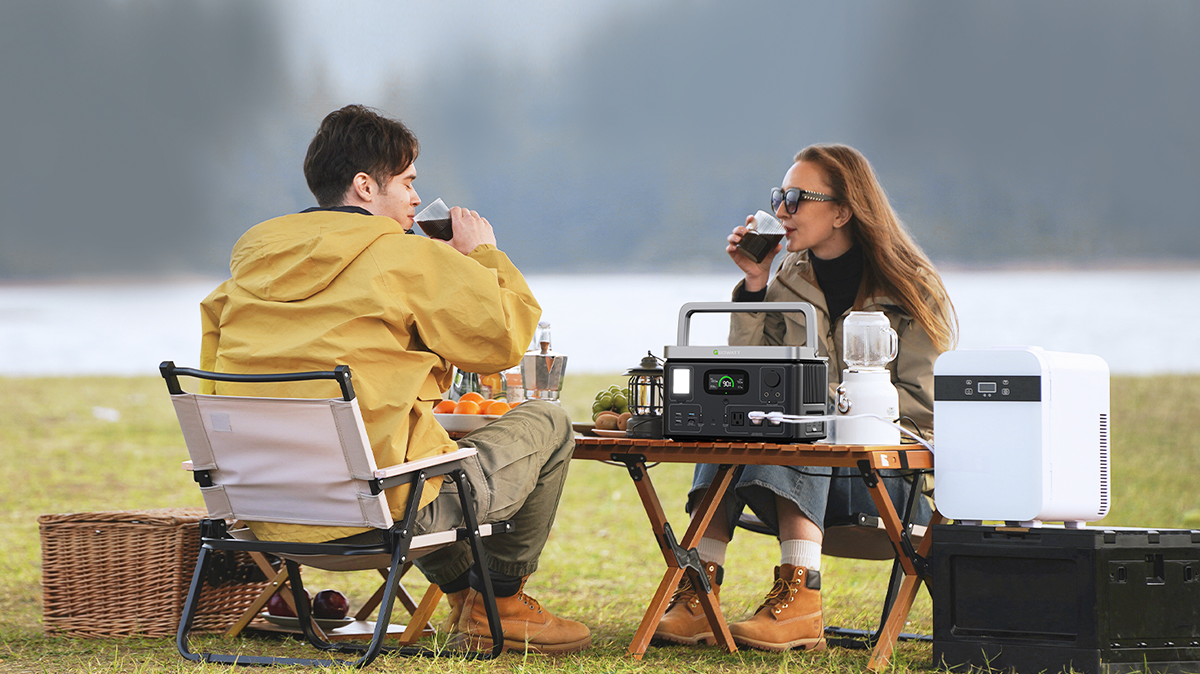 Two people drinking outdoors with a Growatt VITA 550 on a table between them