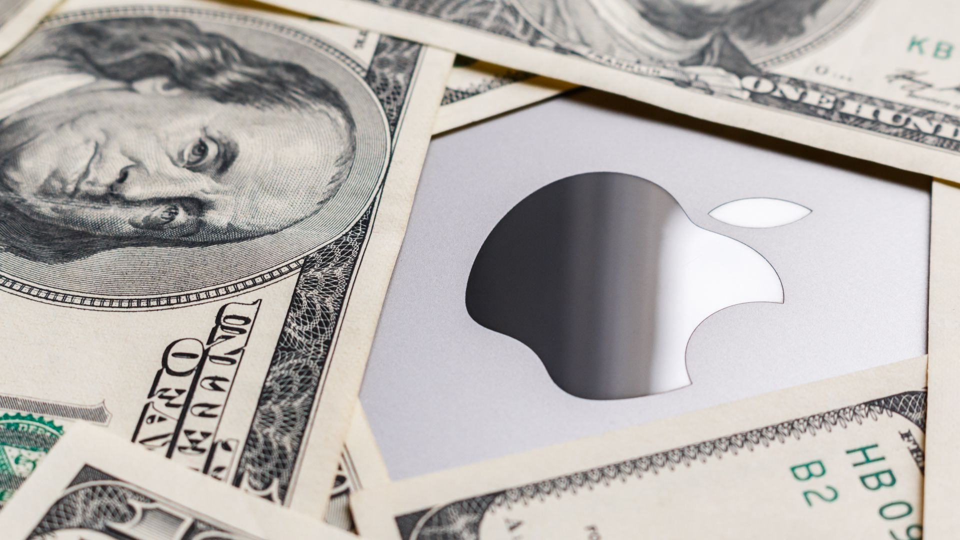 $100 bills surround an Apple logo