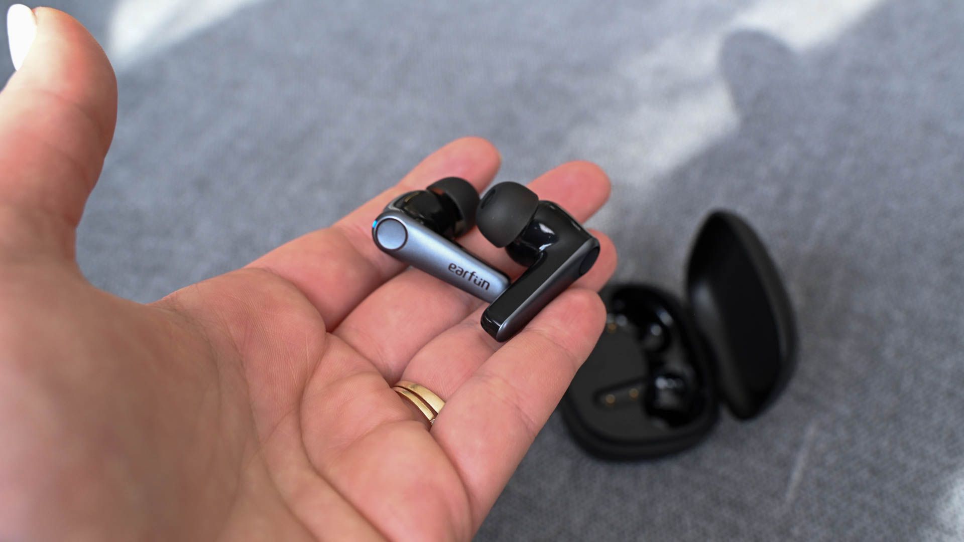 Person holding a pair of EarFun Air Pro 3 buds