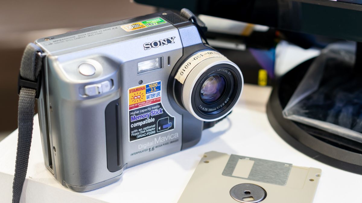 A vintage Sony digital camera next to a floppy disk storage device.