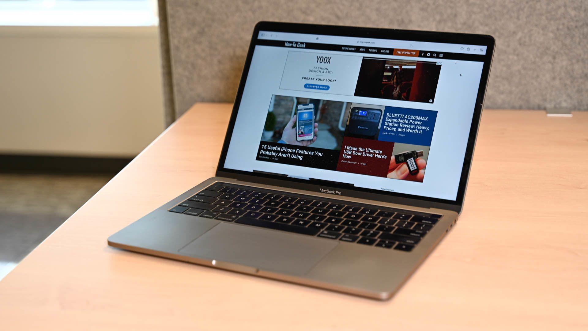A MacBook Pro with How-To Geek's website open on screen.