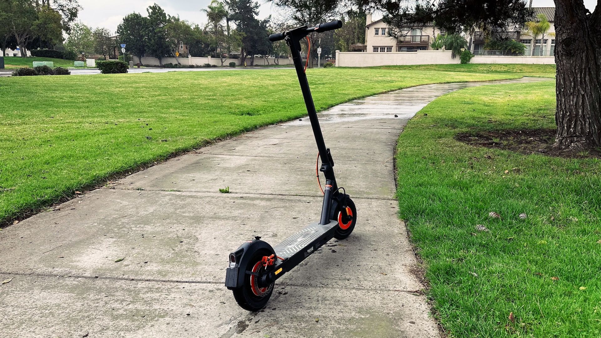 Looking at the electric scooter on a sidewalk from the rear
