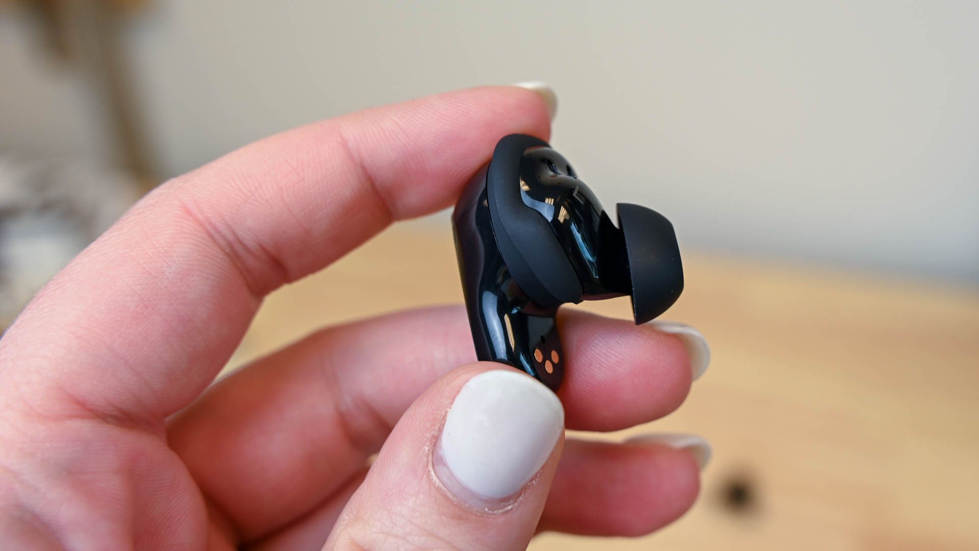 A person holding the left Bose QuietComfort Earbud 2