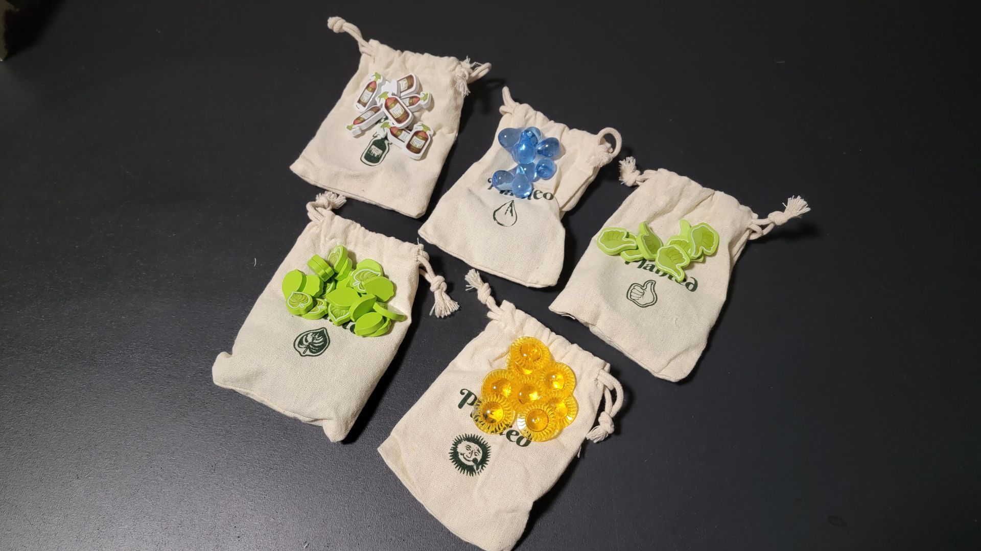 Planted board game resource tokens and cloth storage bags