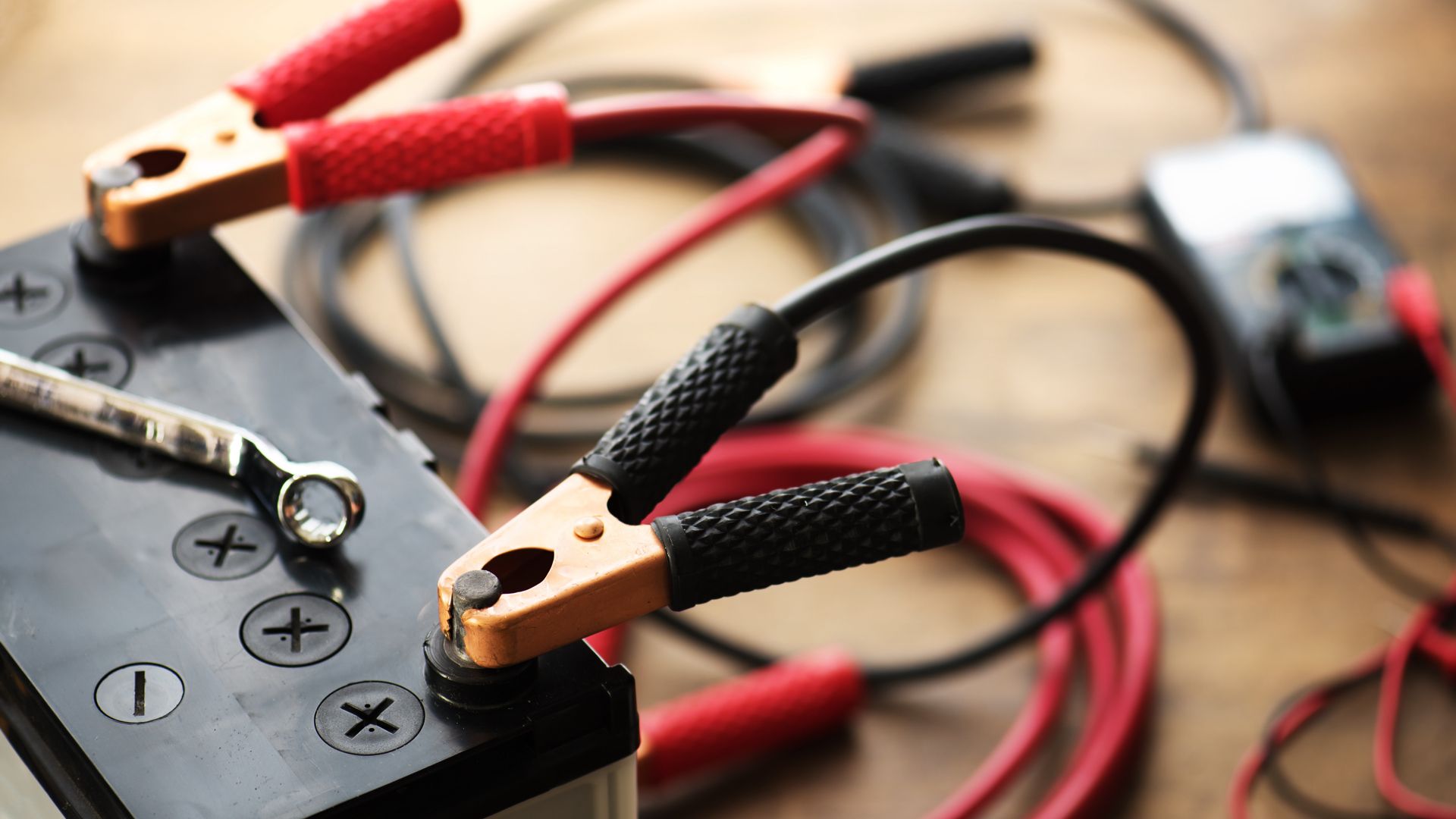 12V car battery with jumper cables attached.