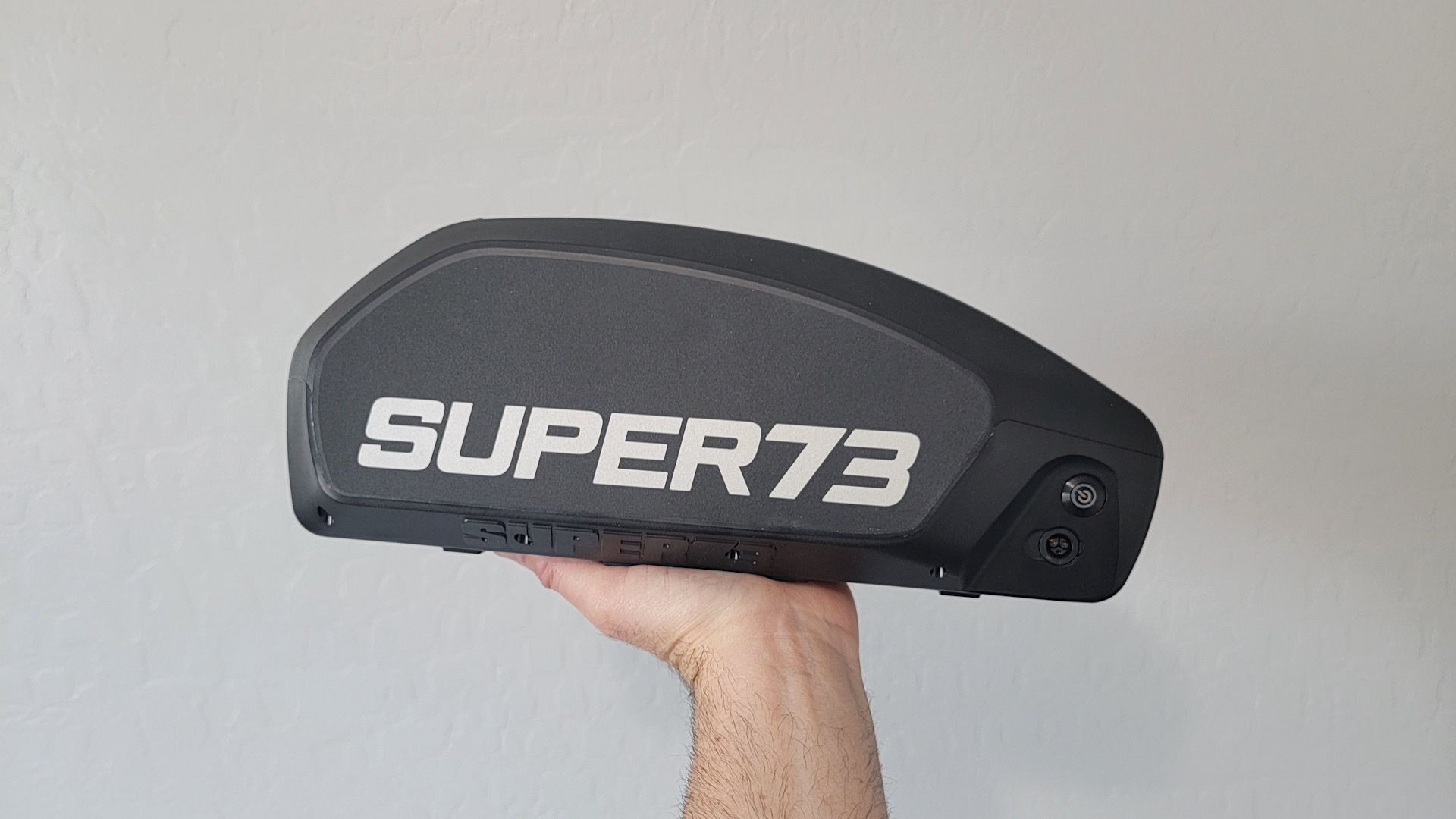 Man holding a Super73 ebike battery.