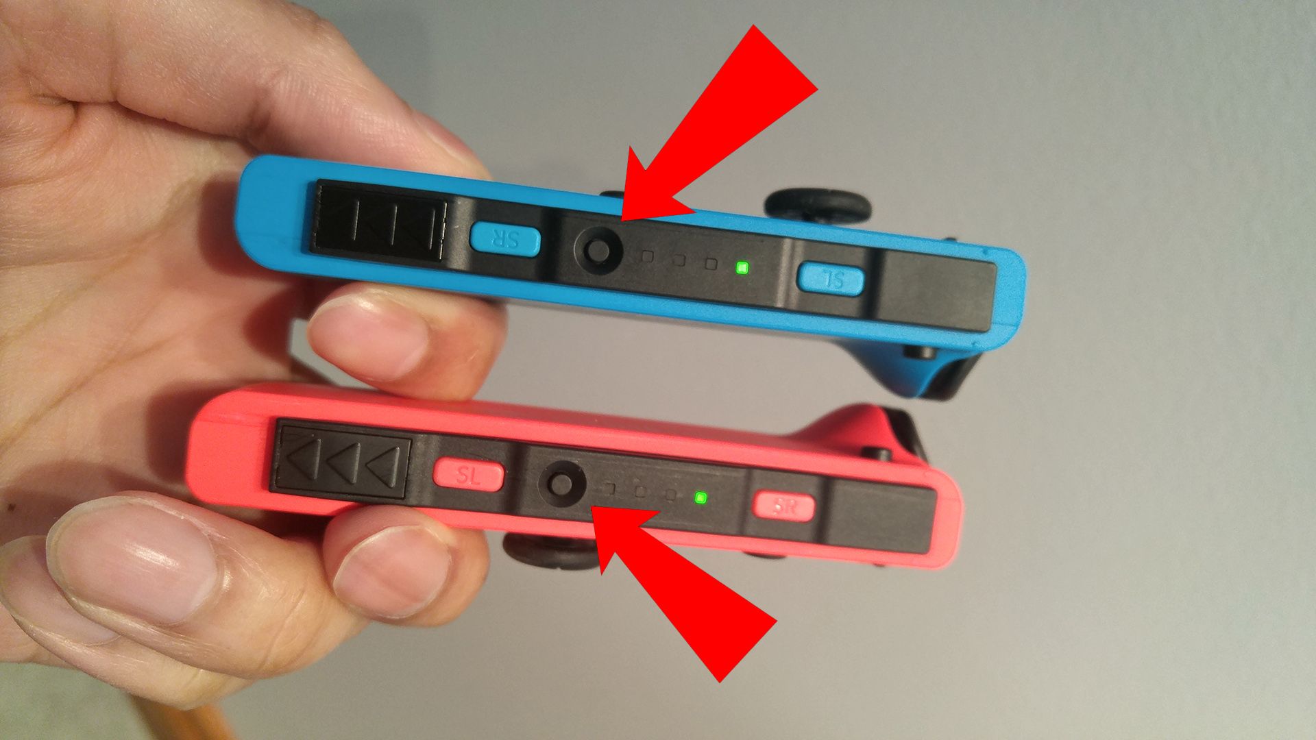 Red arrows pointing to the "Sync" buttons on two Joy-Cons.