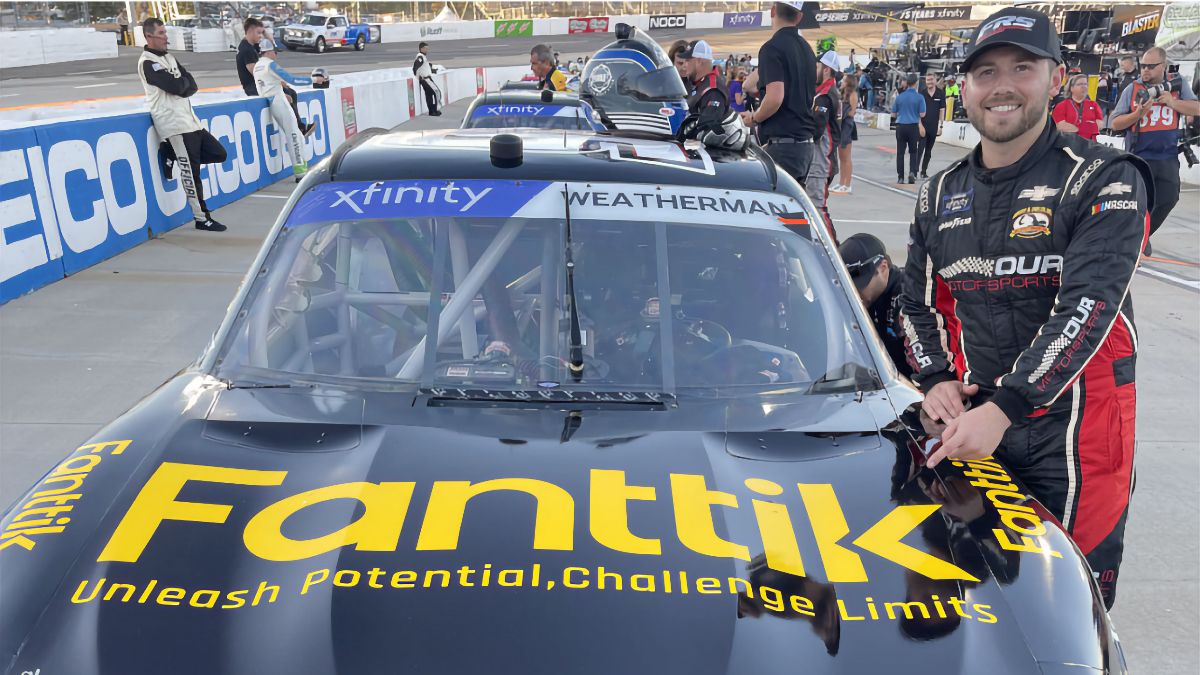 Kyle Weatherman standing with his Fanttik-sponsored Xfinity Series NASCAR racecar