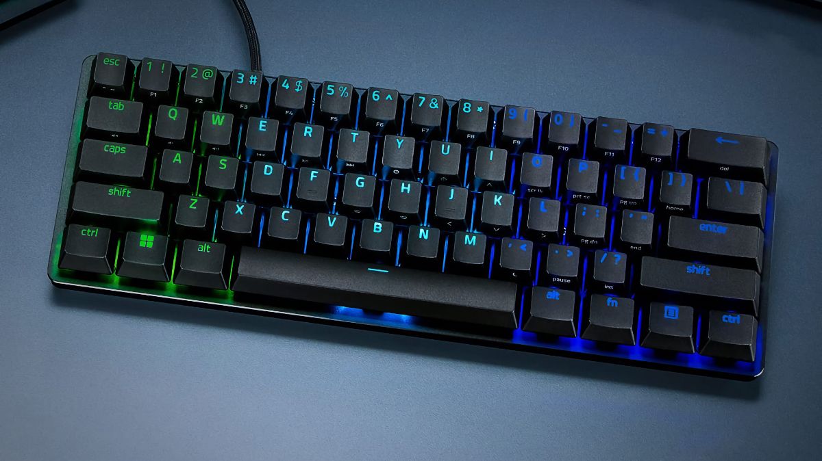 Razer Huntsman Mini Gaming Keyboard lit up with Chroma RGB lights and sitting on a desk