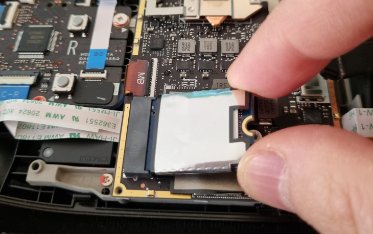 Remove the SSD by unscrewing the screw holding it and then pulling it up with your fingers