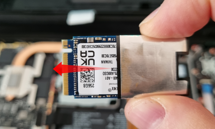 Remove the SSD's ESD shield by holding the shield and pulling the SSD away from it