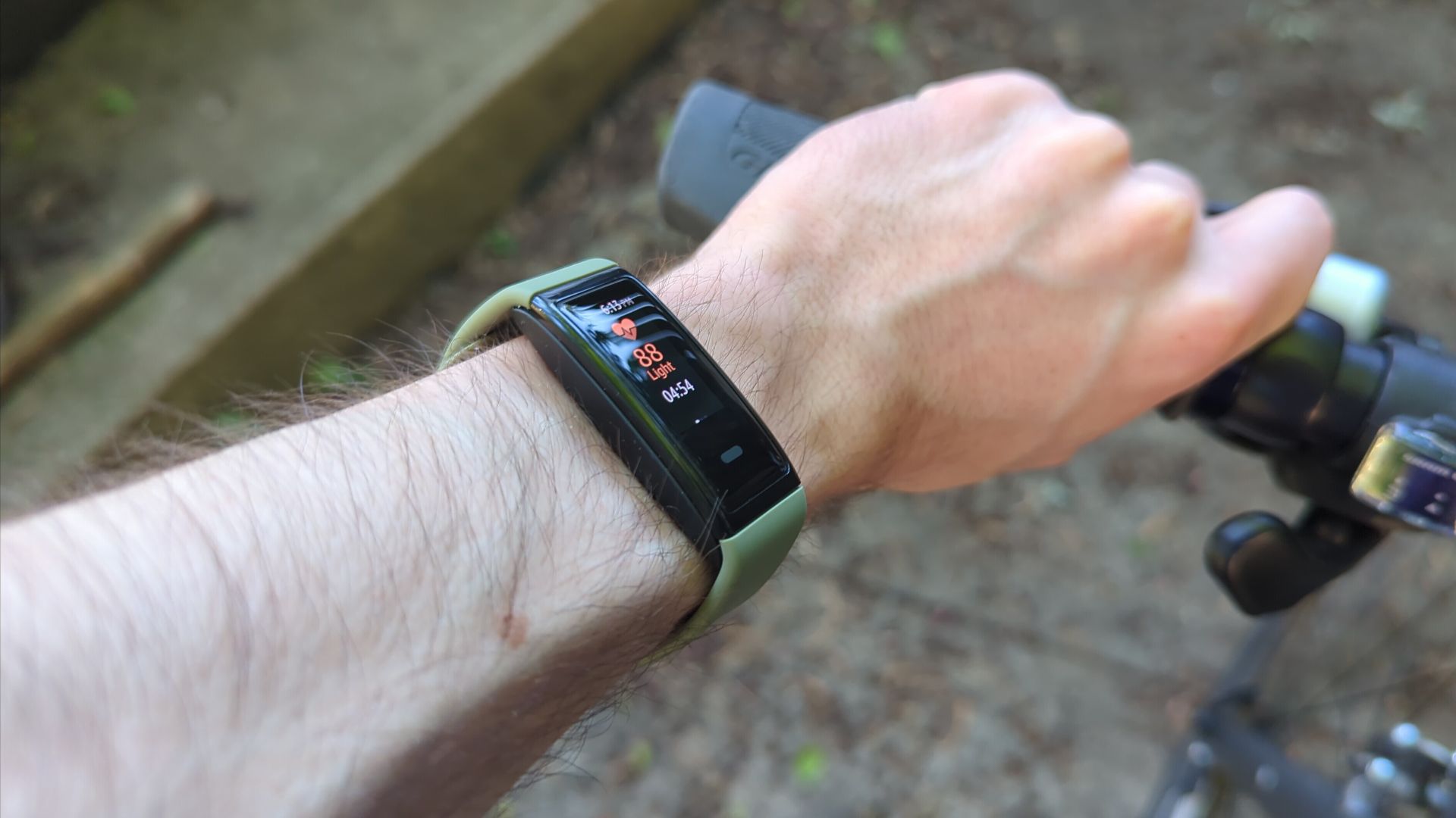 Halo view fitness band on a person's arm holding a bike handle.