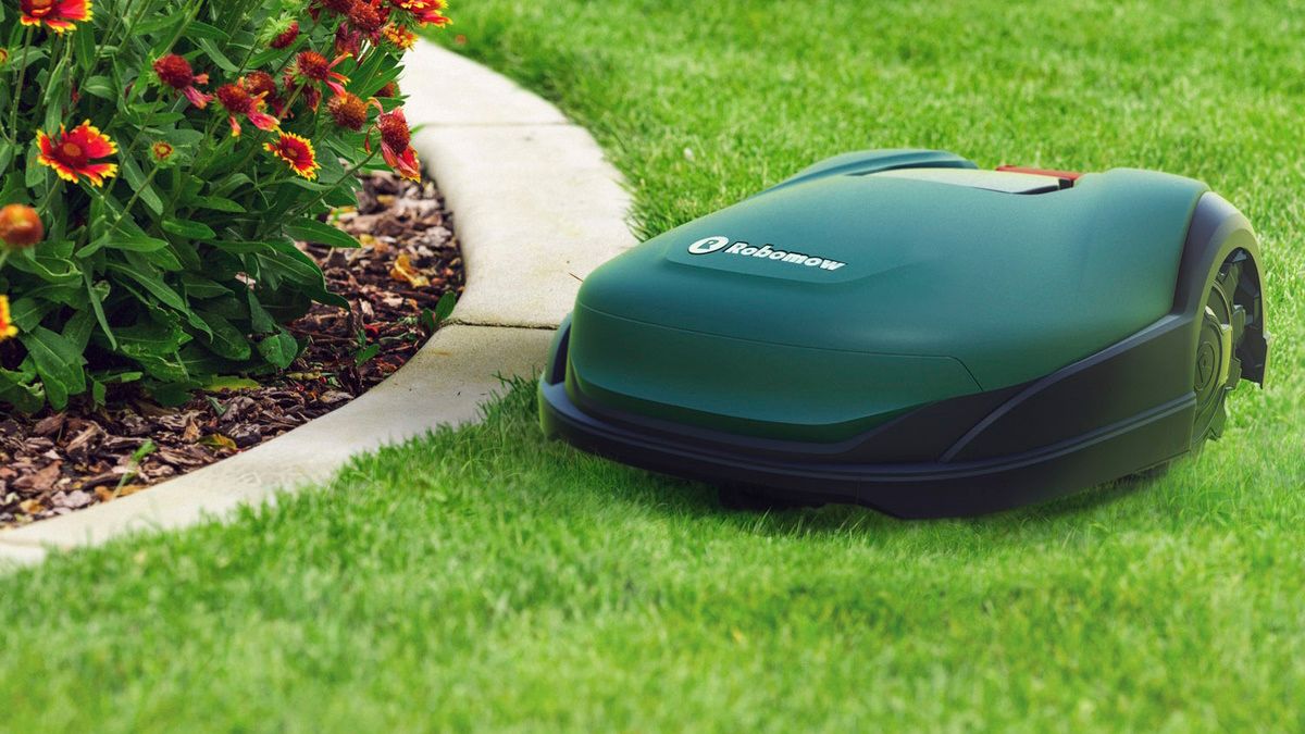 Robomow cutting lawn near garden barrier