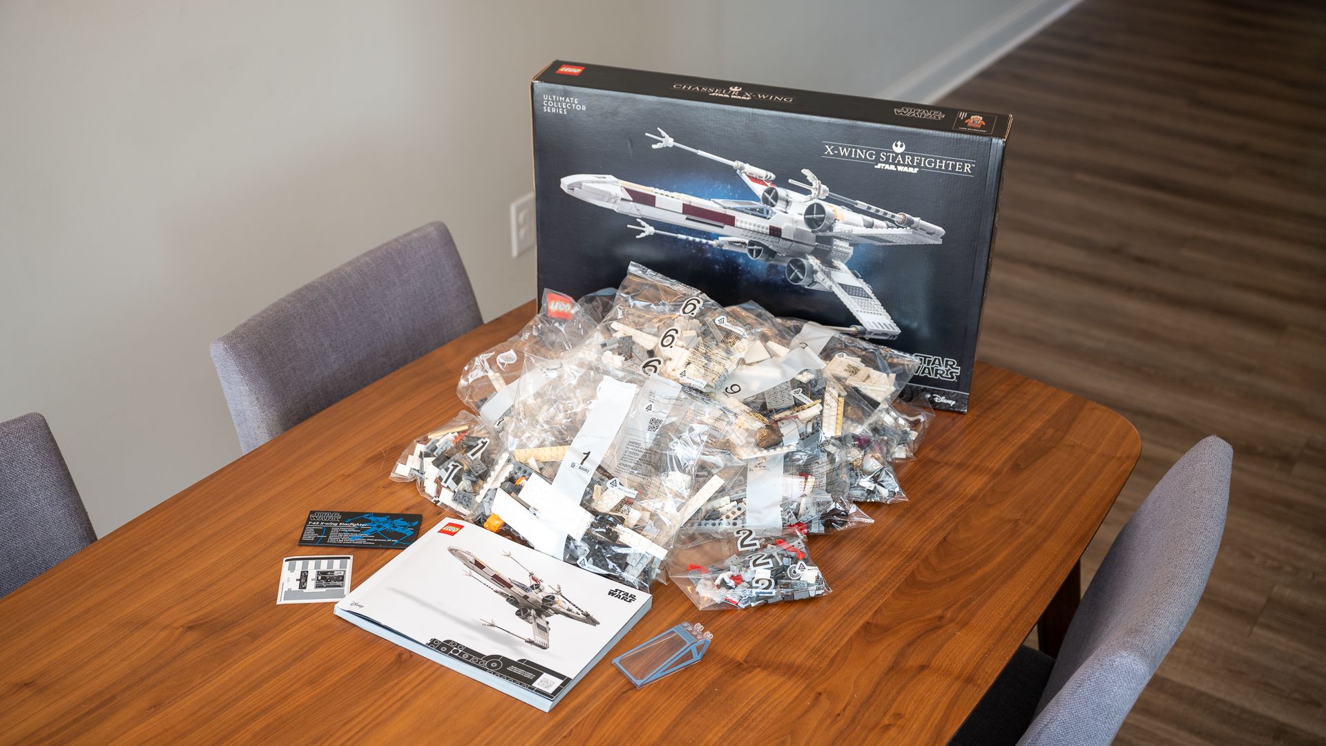 All of the contents of the LEGO Star Wars UCS X-Wing Starfighter box layed out on a table