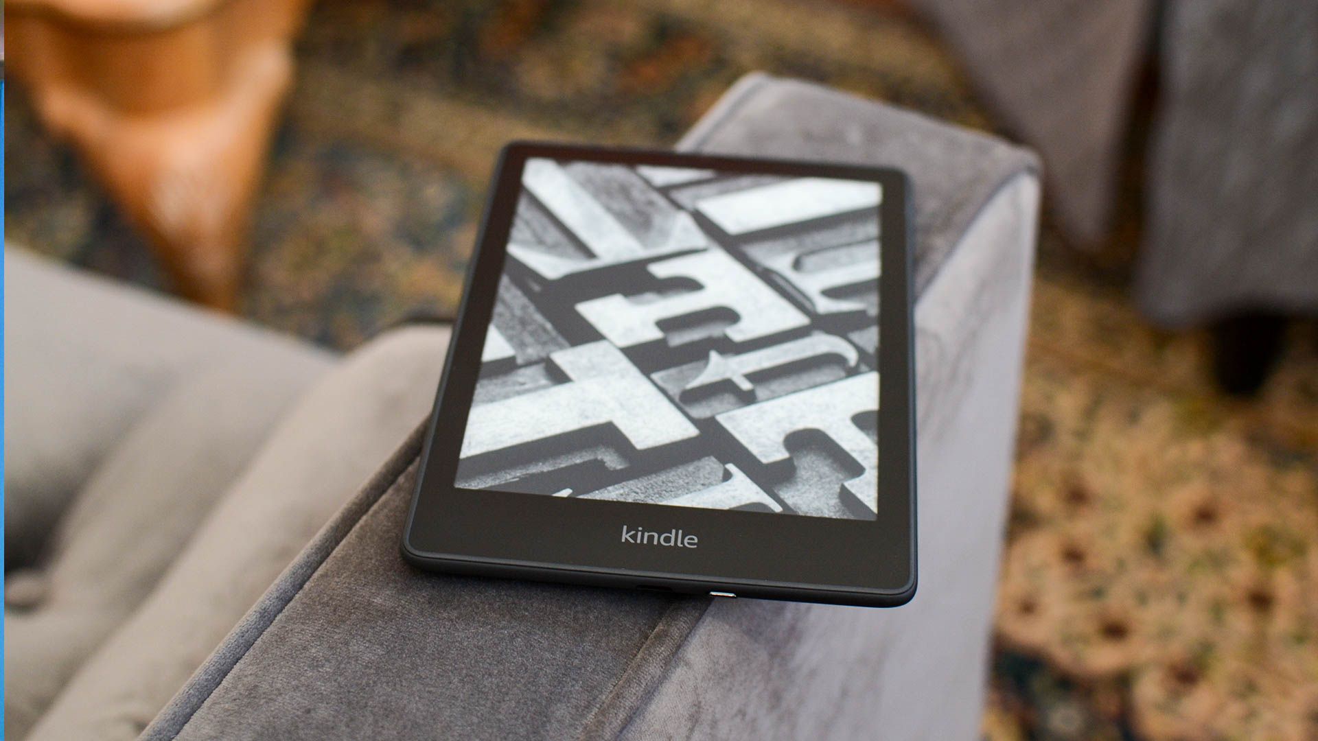 Kindle Paperwhite Signature Edition displaying lock screen on a couch arm