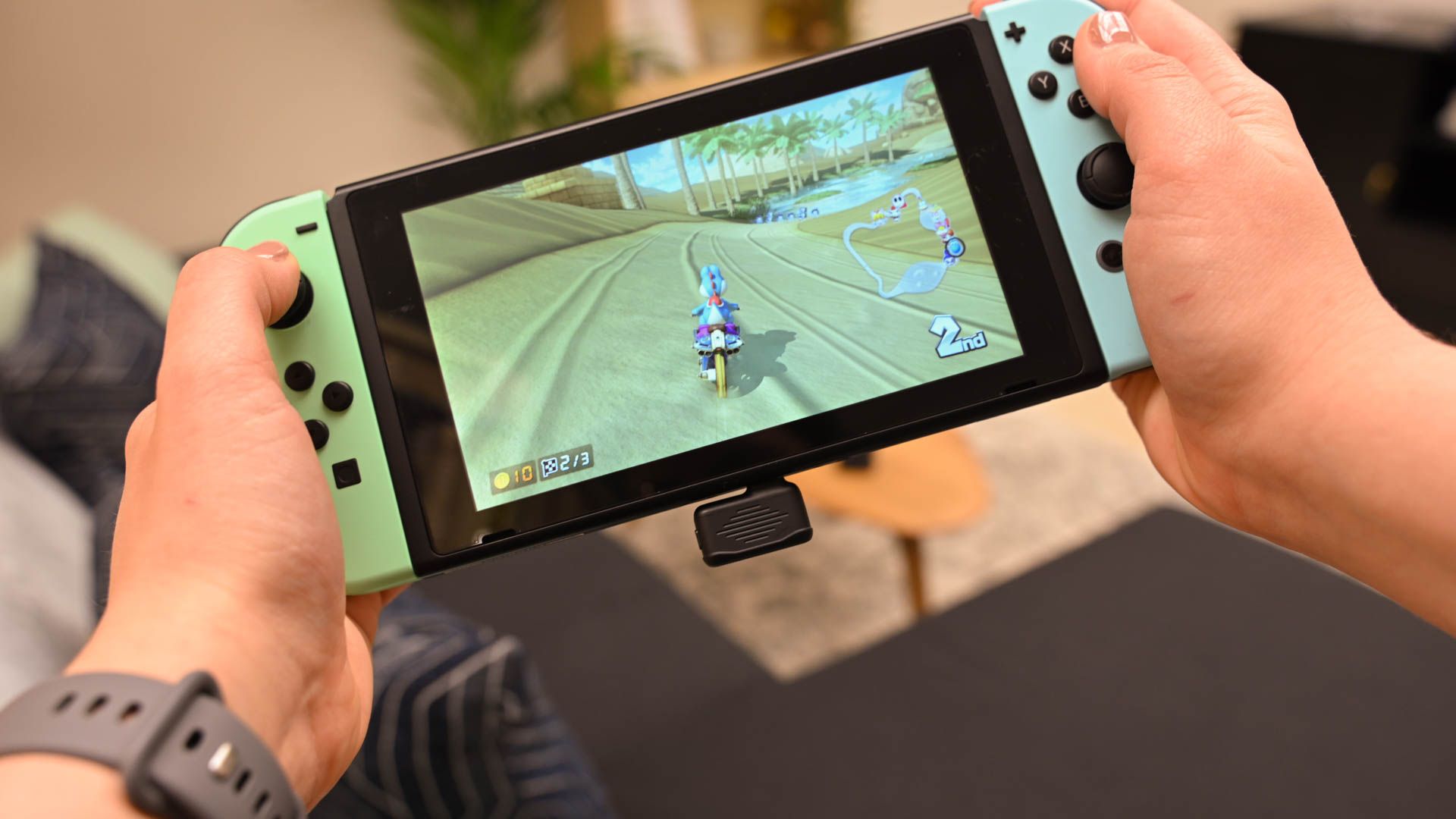 Person playing MarioKart on a Nintendo Switch with the USB wireless dongle of the JBL Quantum TWS Air plugged in