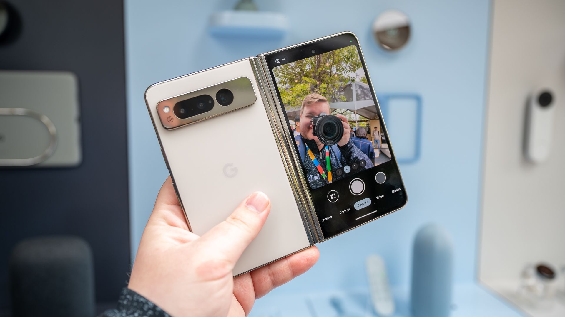 Person holding the Google Pixel Fold while taking a selfie using the rear cameras and front display
