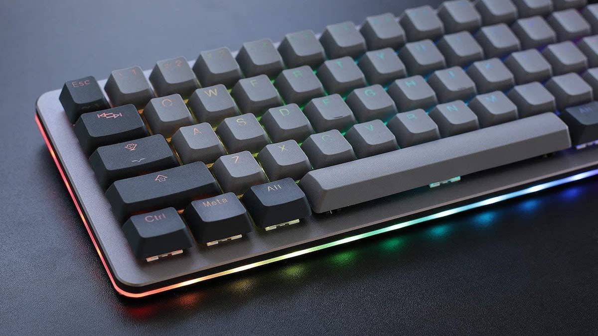 Closeup of a gray mechanical keyboard with rainbow backlighting.