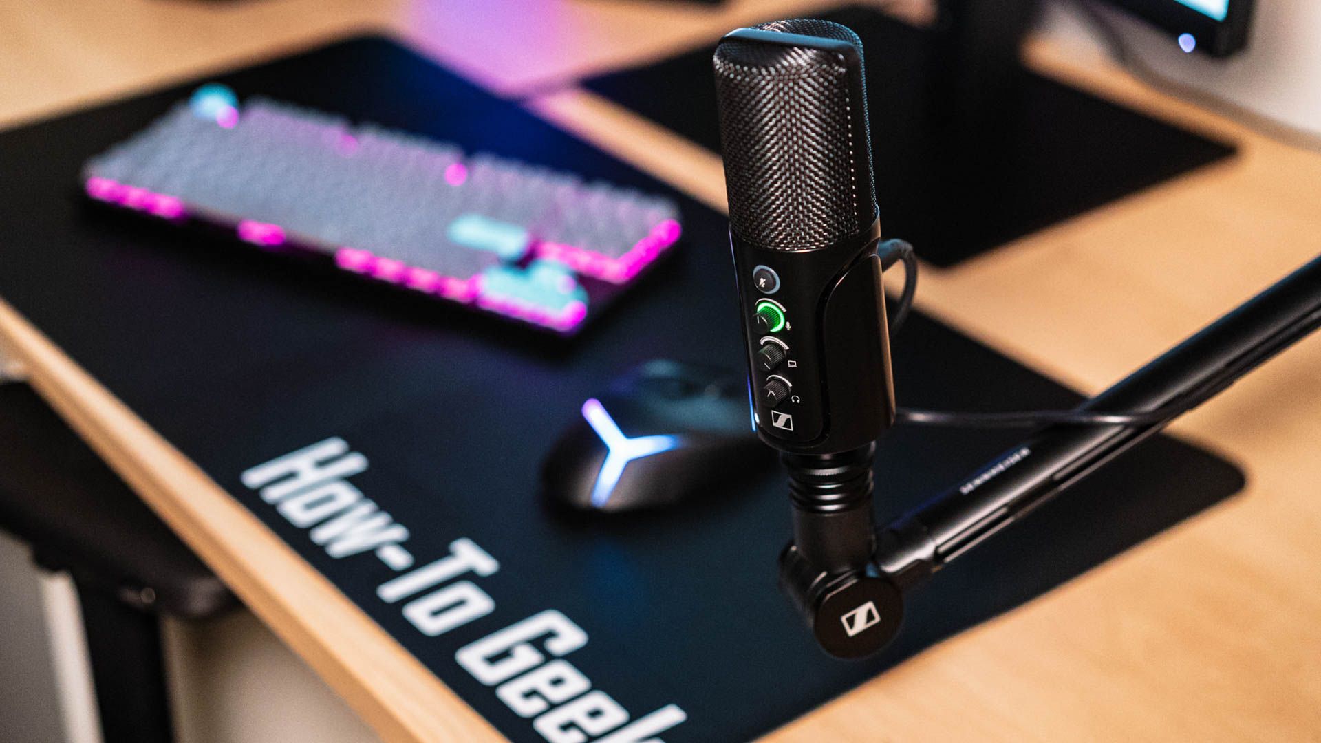 Micro USB Sennheiser Profile sur un bureau avec un clavier led et un sous-main How-To Geek