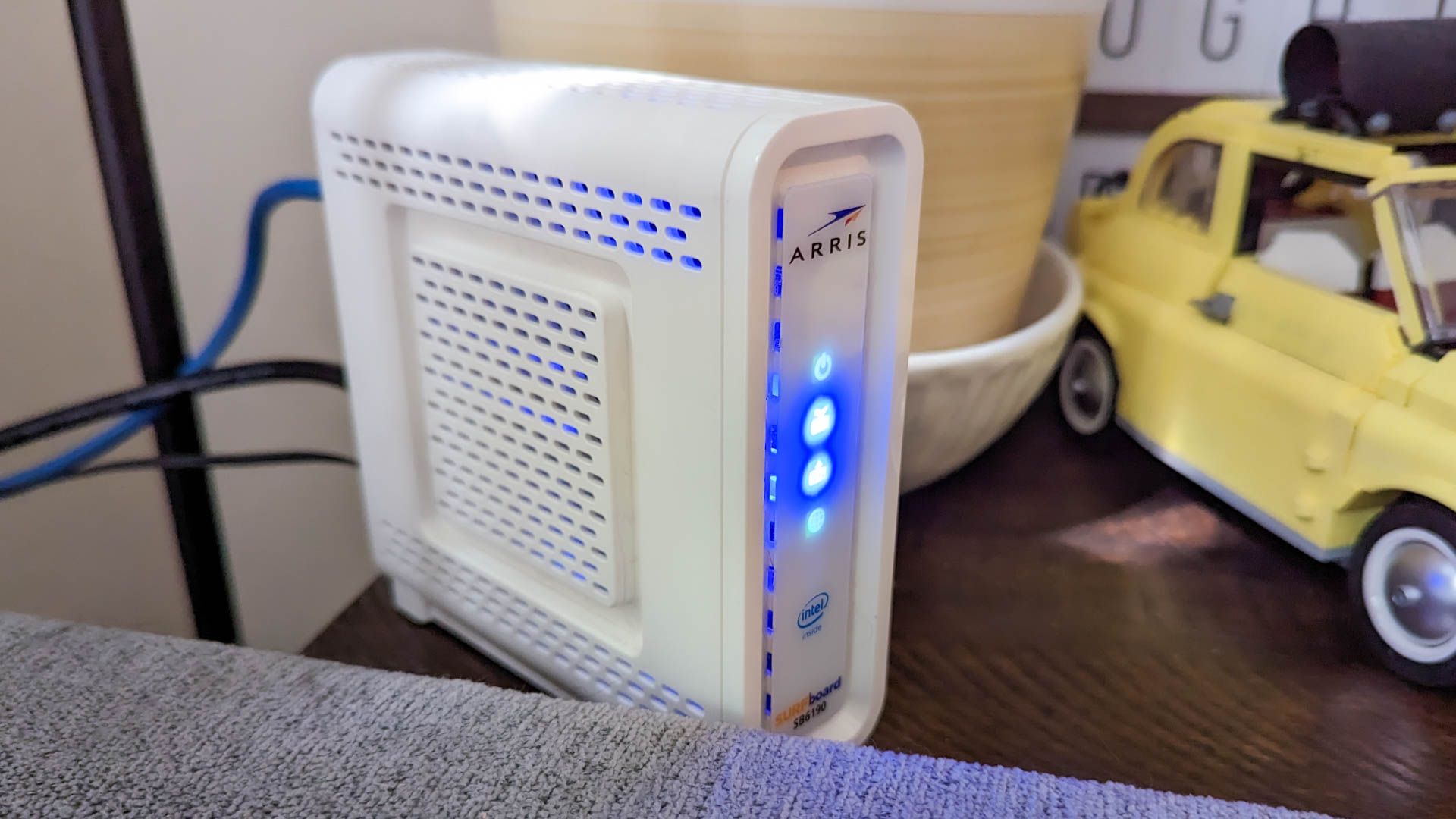 Un modem Arris installé derrière un canapé