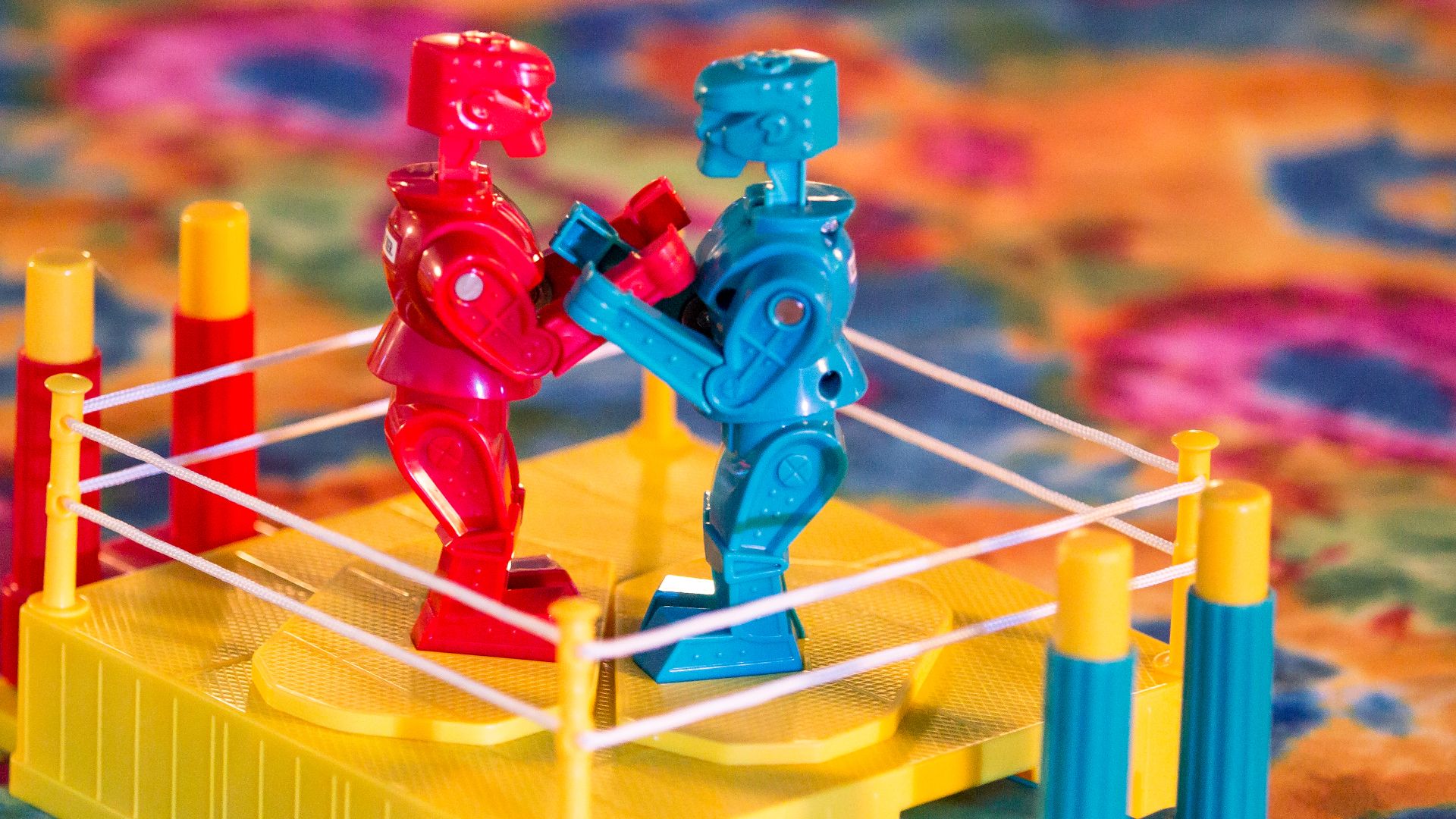 Kids brightly colored boxing robots game on multicolored table top.