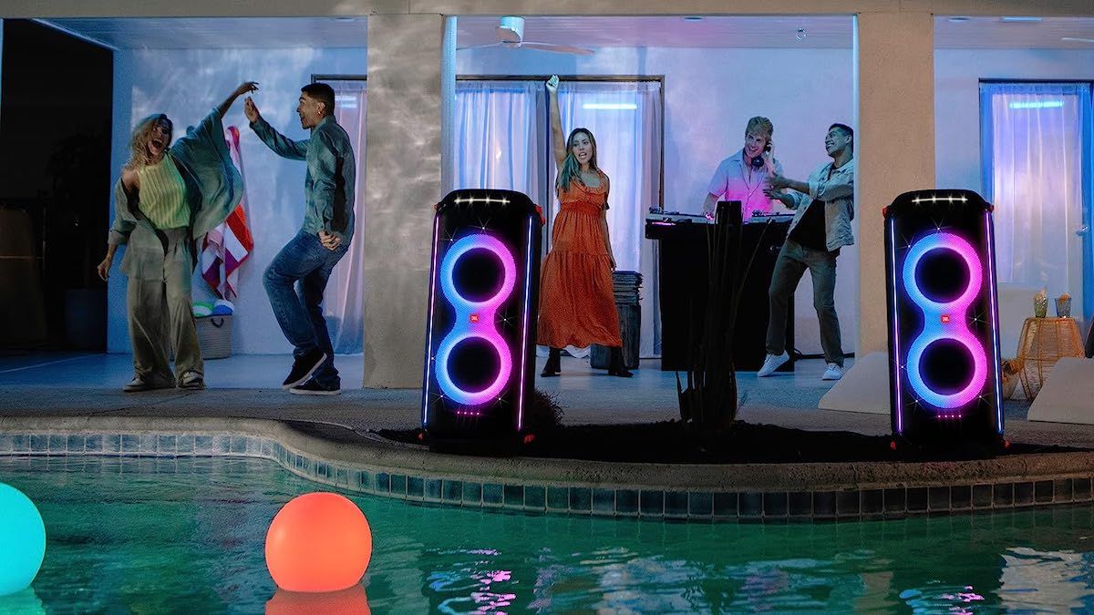 People enjoying music at a pool party with two JBL PartyBox 710s.