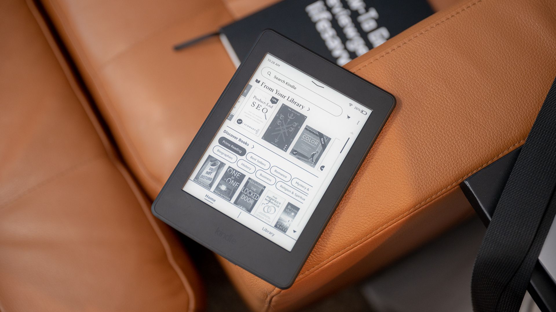2015 Amazon Kindle Paperwhite eReader sitting on a couch showing the home screen