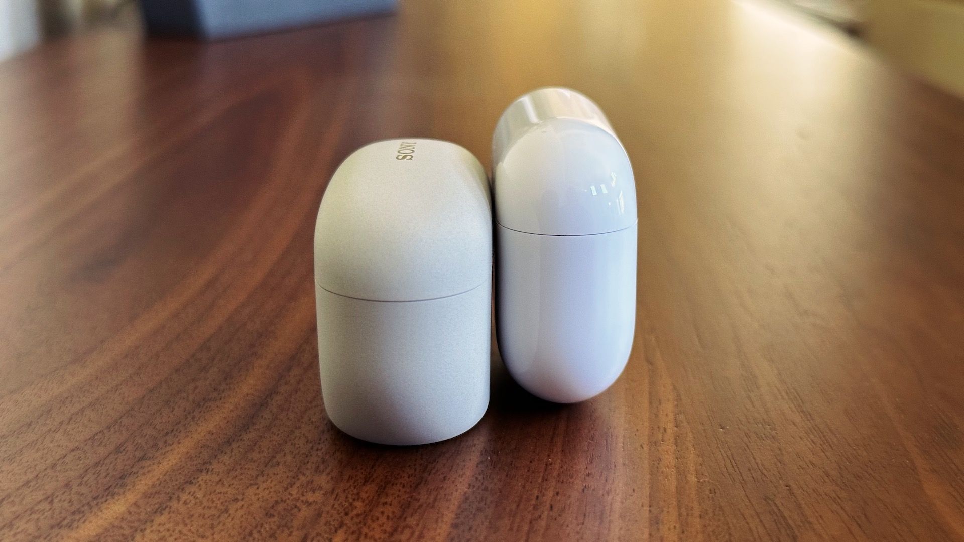 Comparison of WF-1000XM5 charging case on the left and AirPods Pro 2 on the right