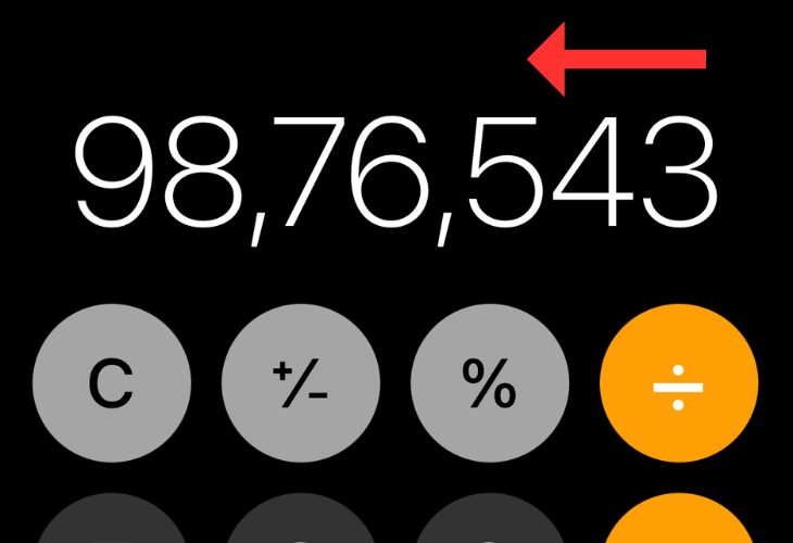 iPhone's calculator app with an arrow indicating the direction to erase input