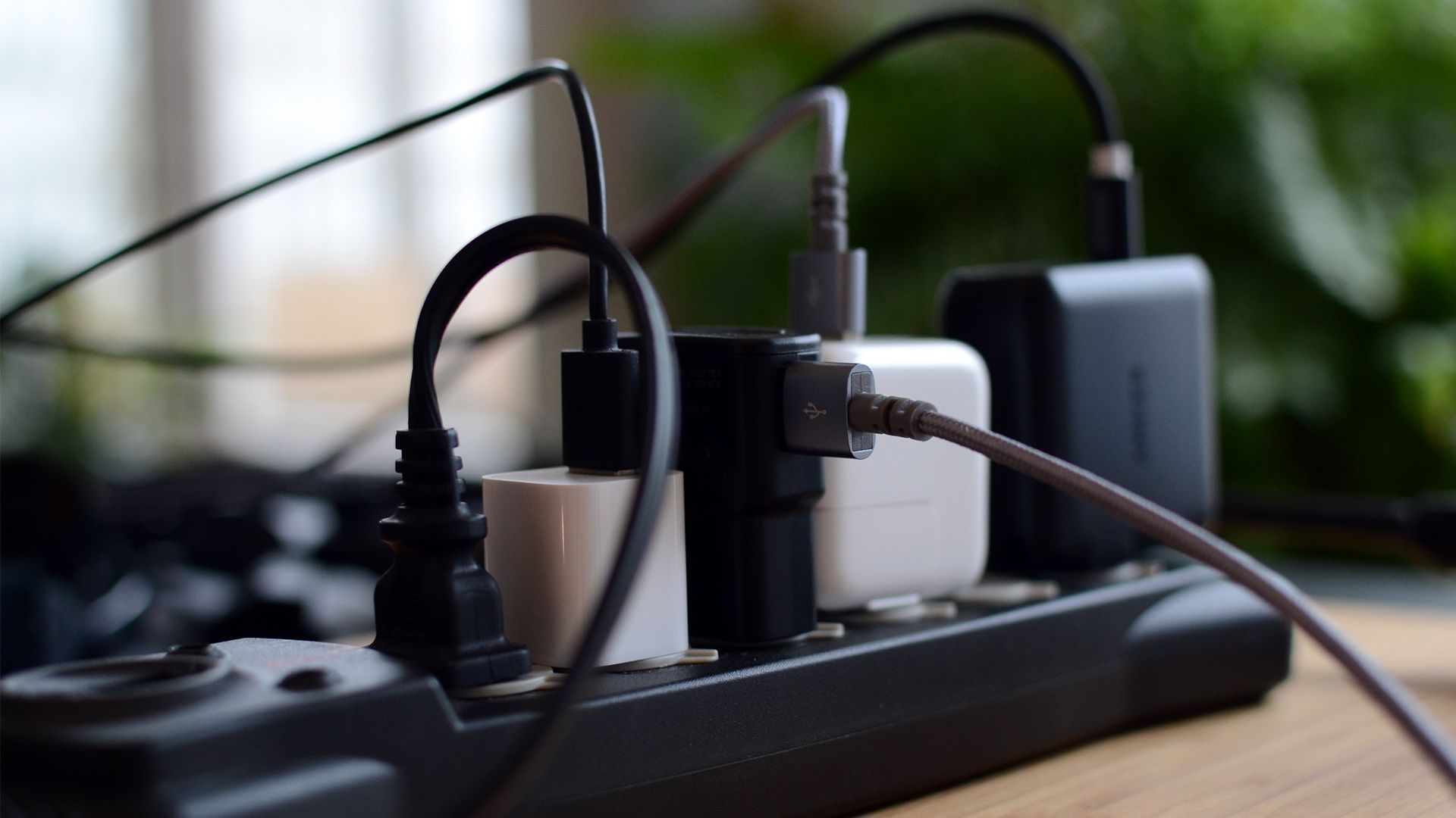 Multiple power adaptors and cables plugged into a power strip