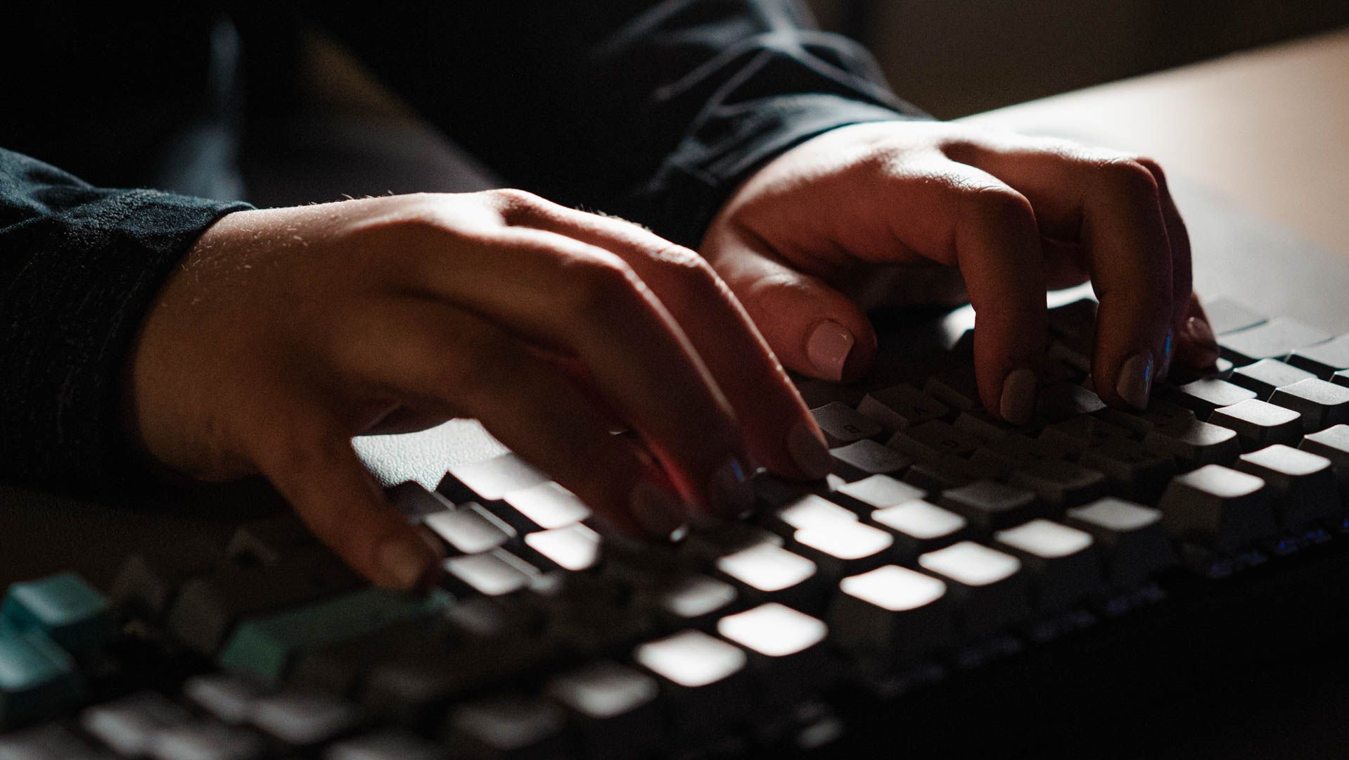 Personne tapant de manière inquiétante sur un clavier sombre.