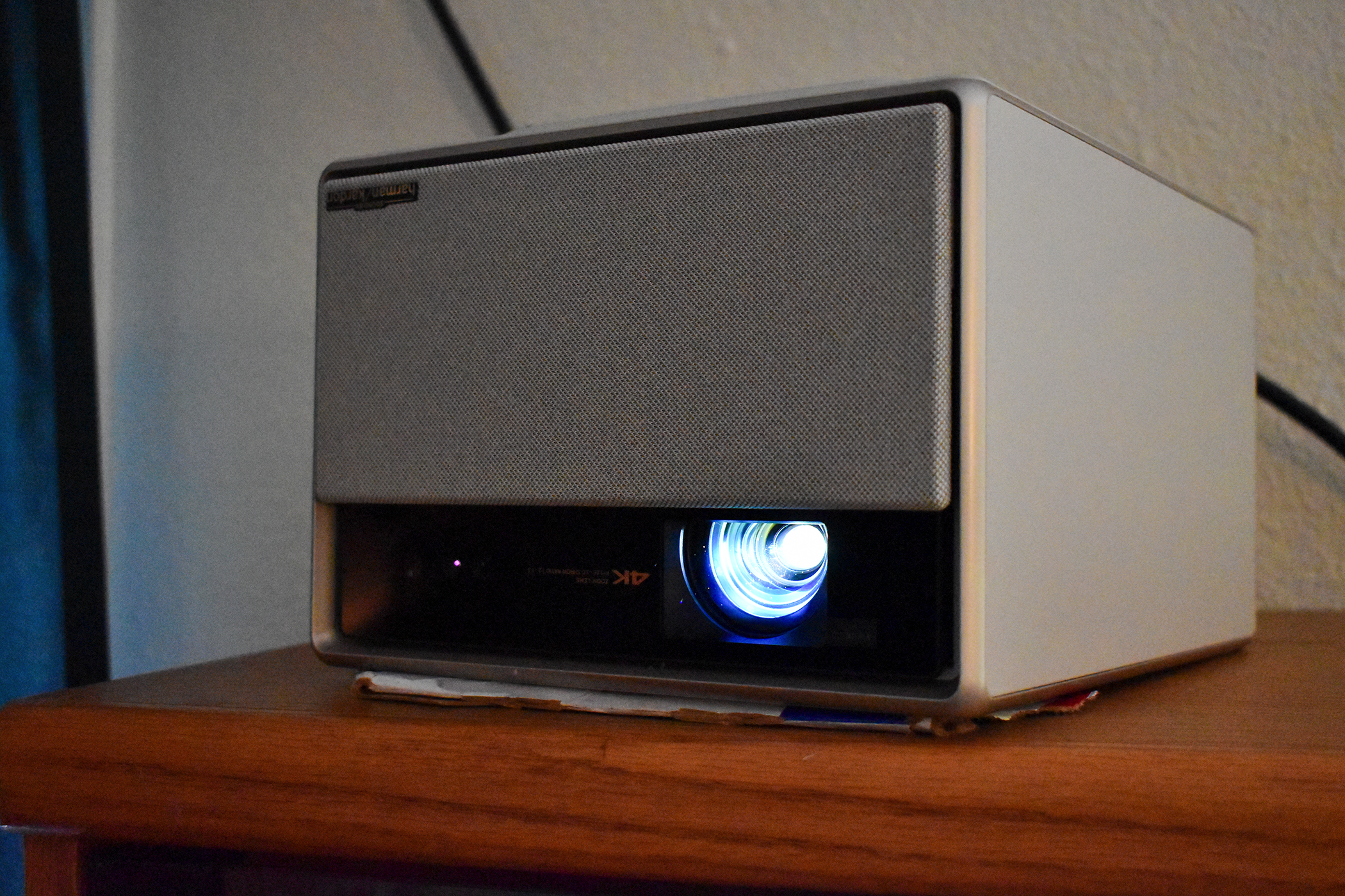 The XGIMI Horizon Ultra placed upside-down on a bookshelf with some cardboard shoved under it to get the right projection angle.
