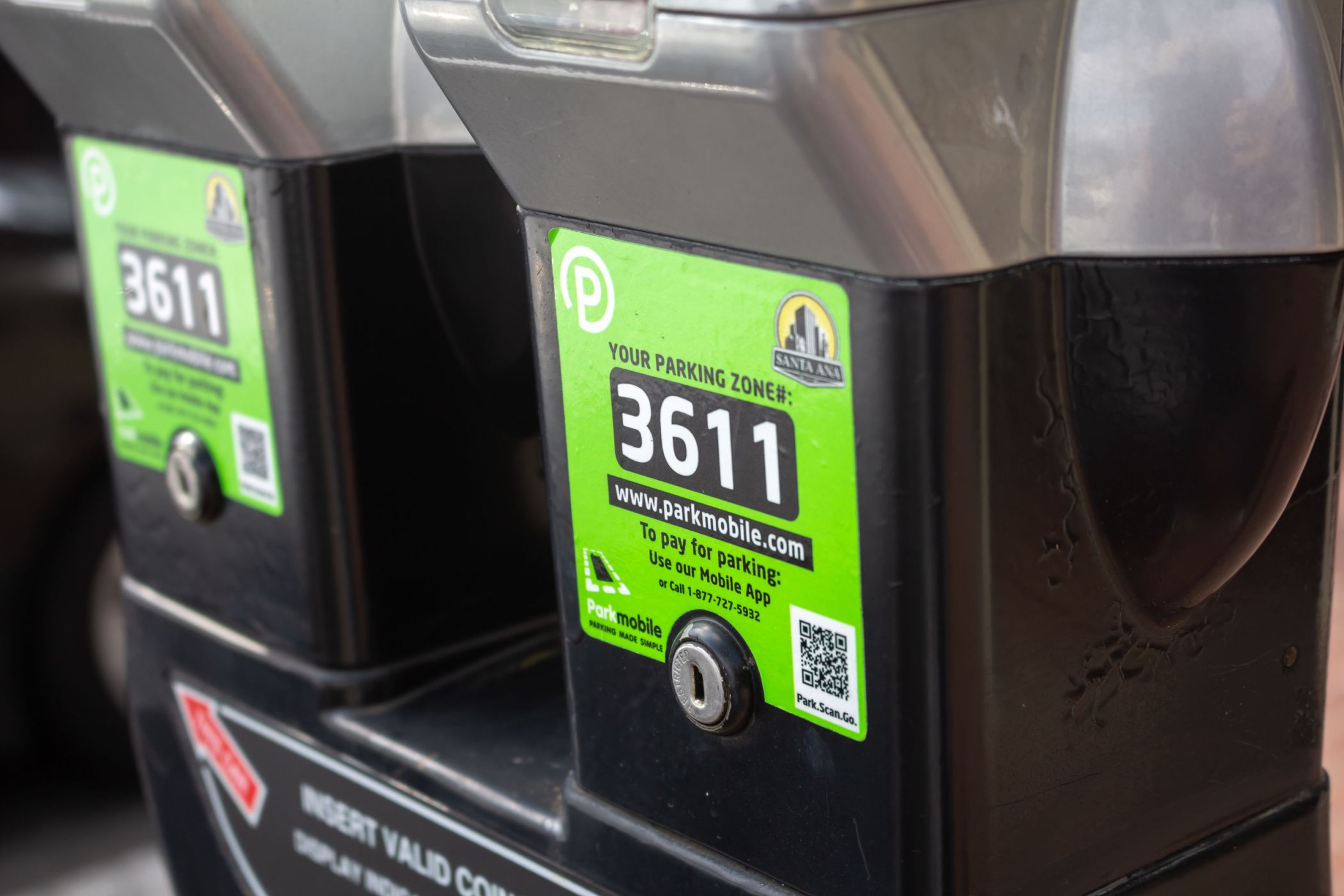 A pair of parking meters with a QR code for easy payment.
