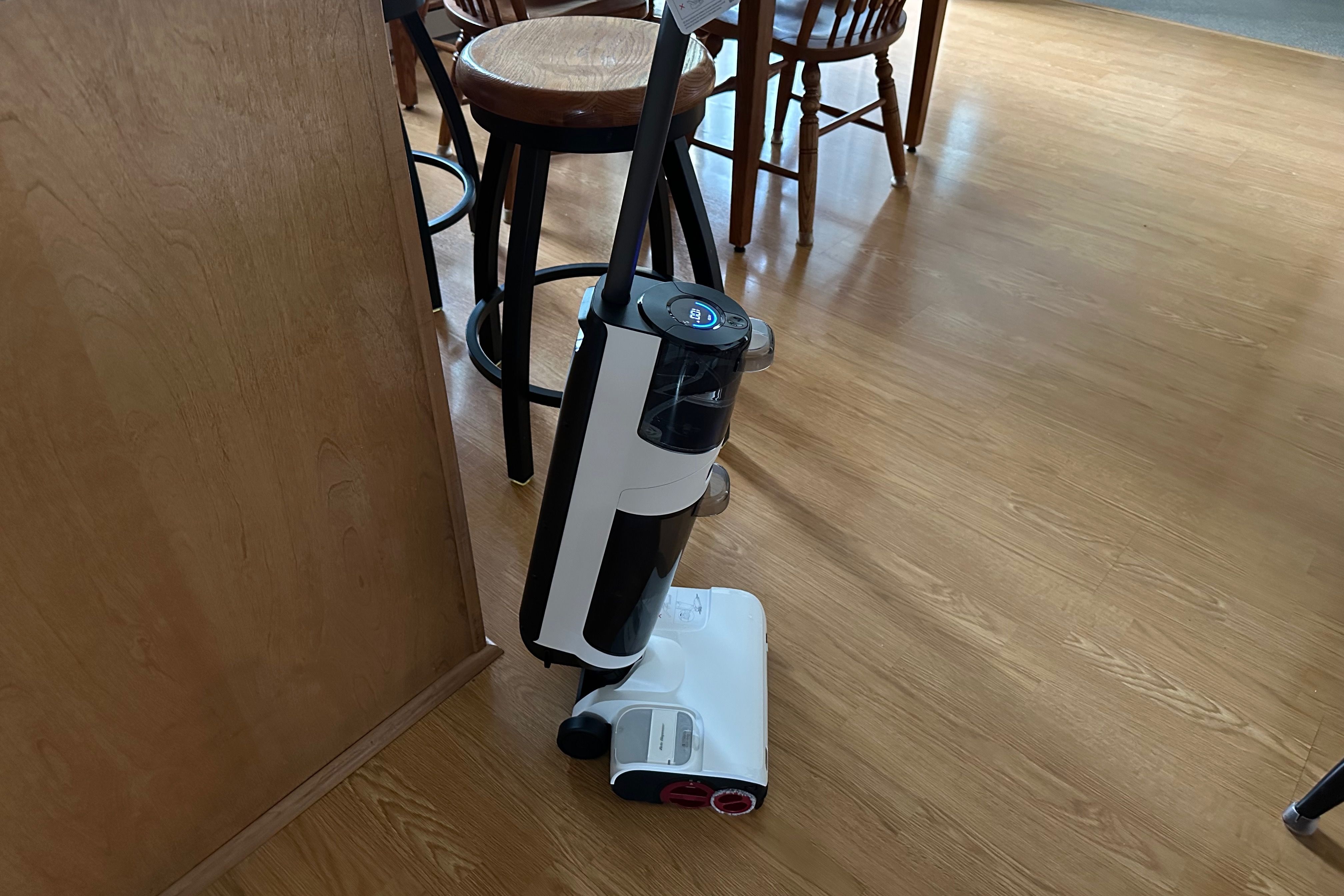 A Roborock Dyad Pro shown in a kitchen on a hardwood floor